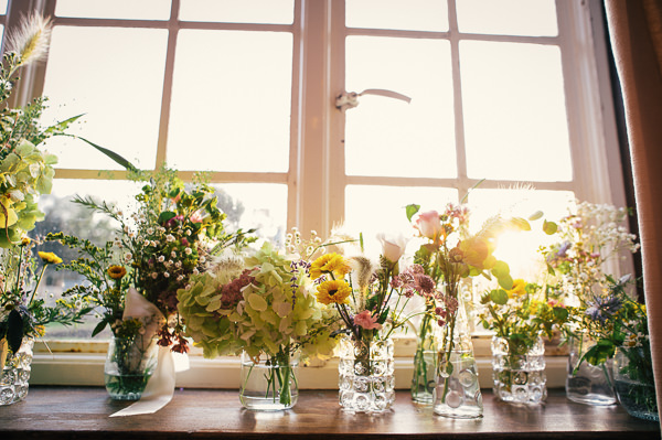 Wild Vintage Flowers Jars Vases Colourful Homemade Village Hall Wedding http://hollydeacondesign.com/
