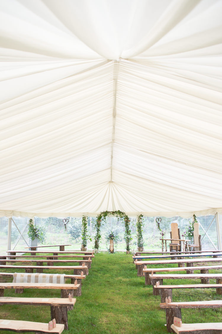 Marquee Ceremony Benches Arch Greenery Foliage Rustic Woodland Glade Wedding http://razzleberryphotography.co.uk/