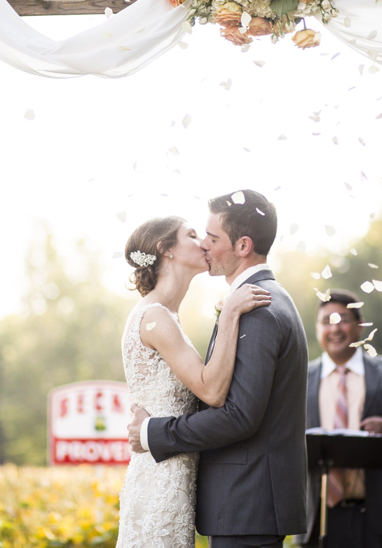 Outdoor Ceremony Flower Petals Arch Peach Roses White Tulle Bride Groom Kiss Country Farm Barn Wedding Ohio http://www.caseyclarkphotography.net/ 