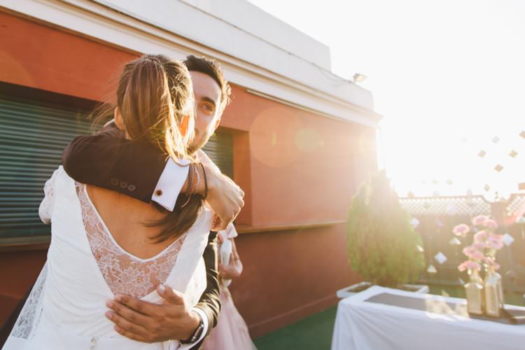 Sunset Bride Three Piece Bridal Gown Low Back Lace Groom Hug Flowers Greenery Modern Roof Terrace Dusk Wedding Madrid http://www.lorenasanjose.com/