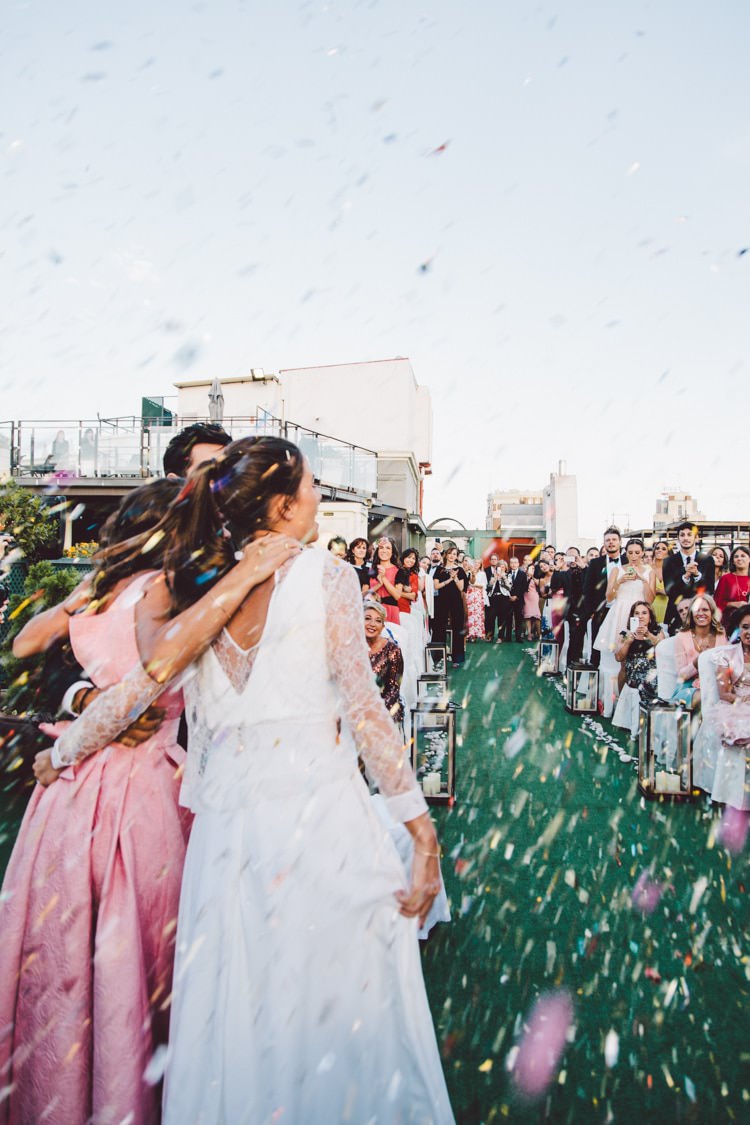 Outdoor Ceremony Celebrant Groom Bride Hugs Confetti Guests Modern Roof Terrace Dusk Wedding Madrid http://www.lorenasanjose.com/