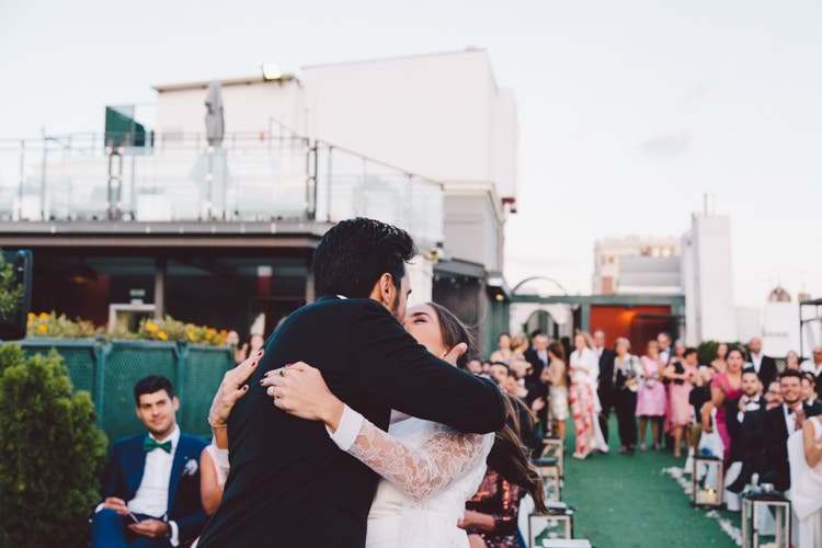 Outdoor Ceremony Groom Bride Kiss Guests Modern Roof Terrace Dusk Wedding Madrid http://www.lorenasanjose.com/