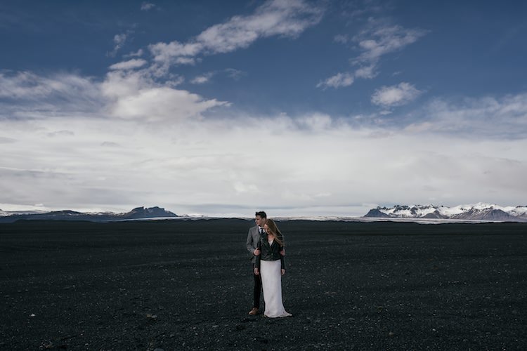 Bride Beaded Stephanie Allin Bridal Gown Leather Jacket Groom Grey Tweed Jacket Tie Skinny Jeans Black Sand Mountains Snow Blue Skies Clouds Glacier Lagoon Iceland Anniversary Shoot http://marcsmithphotography.com/