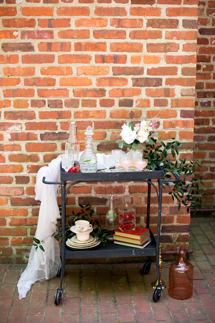 Drinks Tray Retro Décor Glass Bottles Blush Glasses Tea Cups Books Pink Green Florals Tulle Vase Brick Wall Romantic Vintage Wedding Ideas http://katymurrayphotography.com/