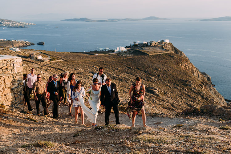 Bride Backless Bridal Gown Blue Shoes Sunglasses Groom Suit Navy Suit Blue Striped Tie Wedding Guests Hill Ocean Breathtaking Intimate Mykonos Destination Wedding http://www.annapumerphotography.com/