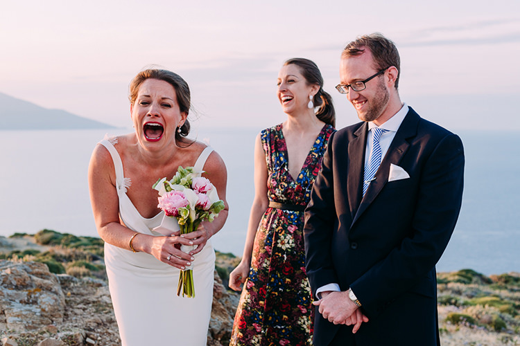 Outdoor Ceremony Bride Backless Bridal Gown Pink White Lillies Bouquet Groom Navy Suit Blue Striped Tie Celebrant Candid Breathtaking Intimate Mykonos Destination Wedding http://www.annapumerphotography.com/