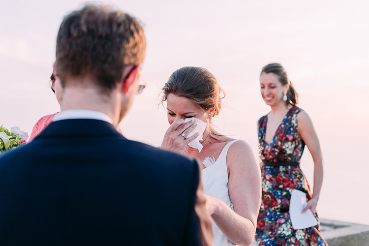 Outdoor Ceremony Bride Backless Bridal Gown Engagement Ring Happy Tears Celebrant Breathtaking Intimate Mykonos Destination Wedding http://www.annapumerphotography.com/