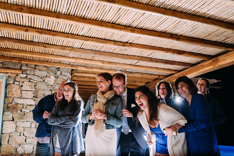 Reception Bride Denim Jacket Scarf Groom Navy Suit Blue Striped Tie Guests Laughter Breathtaking Intimate Mykonos Destination Wedding http://www.annapumerphotography.com/