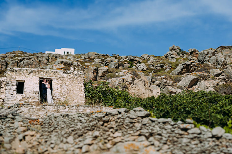 Bride Backless Bridal Gown Groom Hug Brick Stones Blue Sky Breathtaking Intimate Mykonos Destination Wedding http://www.annapumerphotography.com/