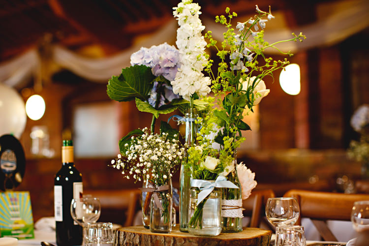Flowers Jars Log Decor Ribbons Blue Rustic Casual Festival Feel Barn Wedding http://hbaphotography.com/