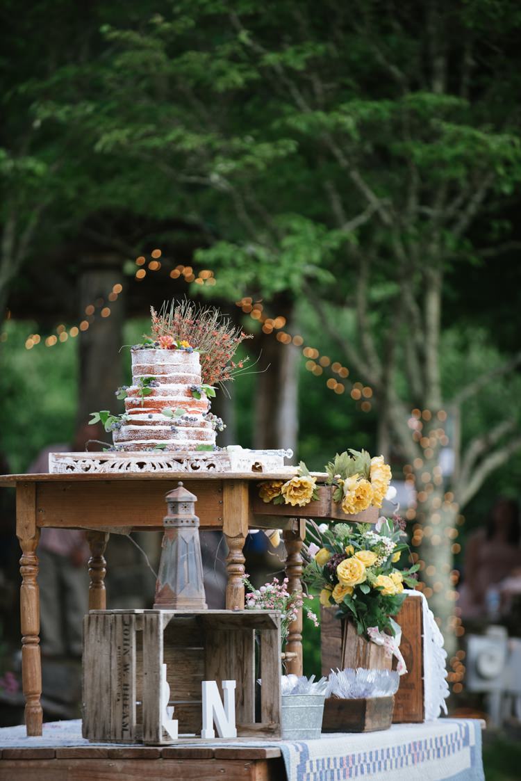 Naked Wedding Cake Topped With Multicoloured Florals Wooden Table Crates Yellow Flowers Rustic Woodsy Wedding North Carolina http://abbyleighanne.com/