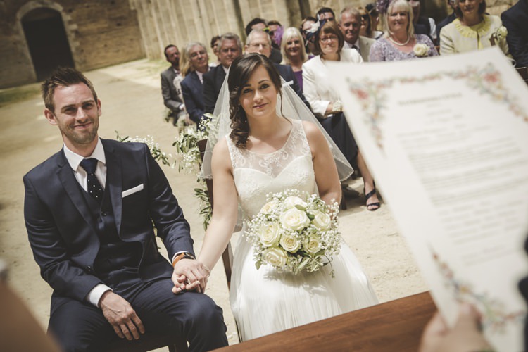 Outdoor Ceremony Bride Lace Sleeveless Bridal Gown Loose Curls Veil Bouquet Cream Roses Gypsophila Groom Navy Blue Suit Polka Dot Tie White Pocket Square Guests Atmospheric Abbey Tuscany Wedding http://www.angelicabraccini.com/