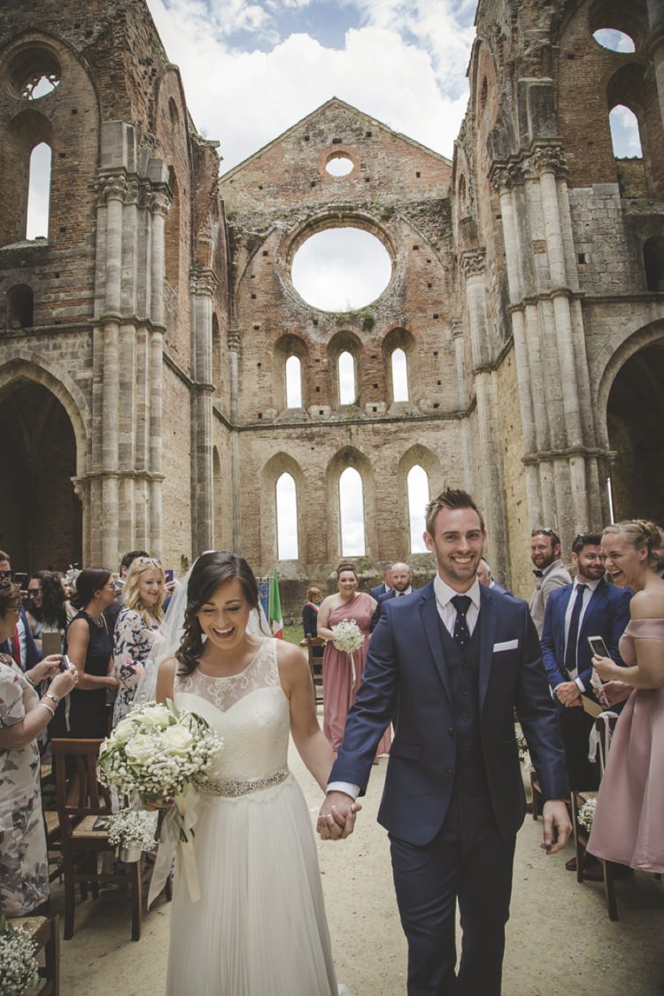 Outdoor Ceremony Bride Lace Sleeveless Bridal Gown Beaded Belt Loose Curls Veil Bouquet Cream Roses Gypsophila Groom Navy Blue Suit Polka Dot Tie White Pocket Square Bridesmaids Groomsmen Guests Atmospheric Abbey Tuscany Wedding http://www.angelicabraccini.com/