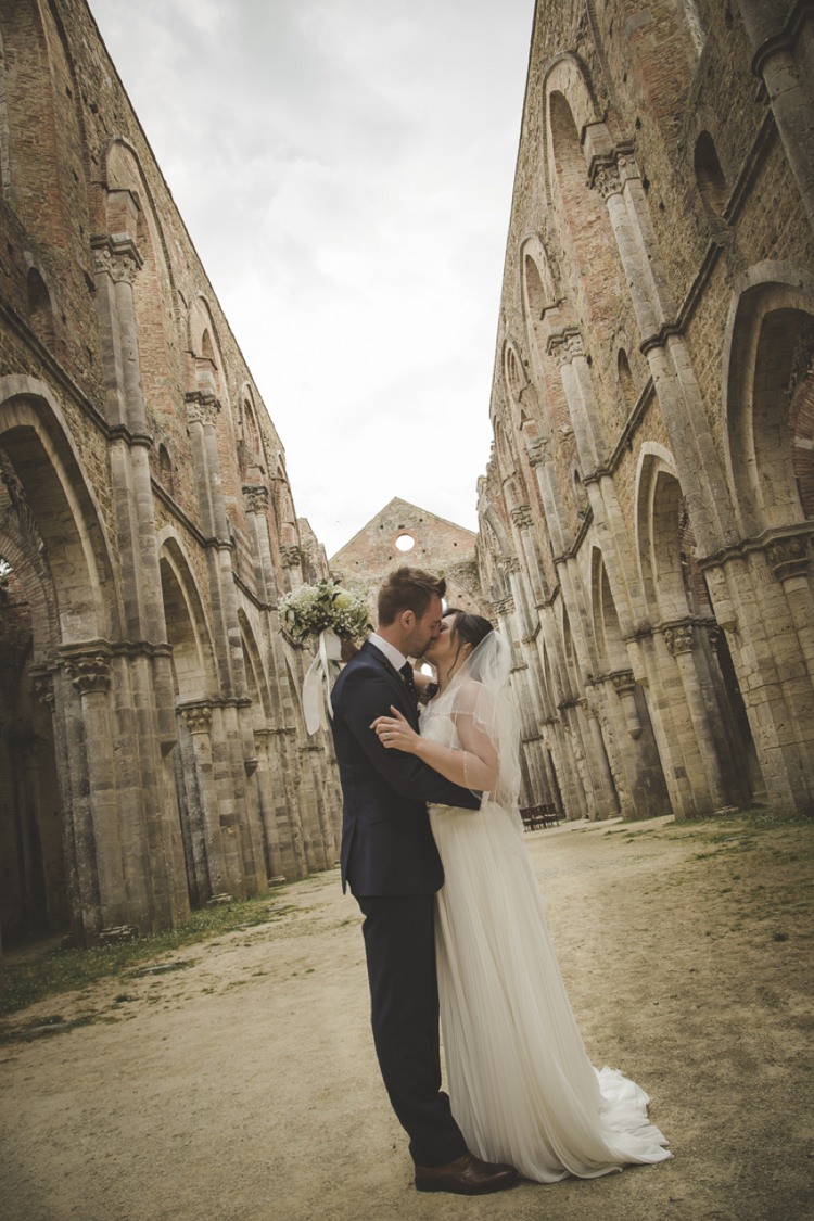 Outdoor Ceremony Bride Lace Sleeveless Bridal Gown Loose Curls Veil Bouquet Cream Roses Gypsophila Groom Navy Blue Suit Polka Dot Tie Kiss Atmospheric Abbey Tuscany Wedding http://www.angelicabraccini.com/