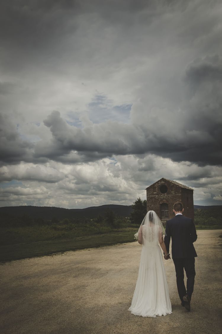 Bride Lace Sleeveless Bridal Gown Veil Groom Navy Blue Suit Green Hillside Dirt Road Dark Cloudy Skies Atmospheric Abbey Tuscany Wedding http://www.angelicabraccini.com/