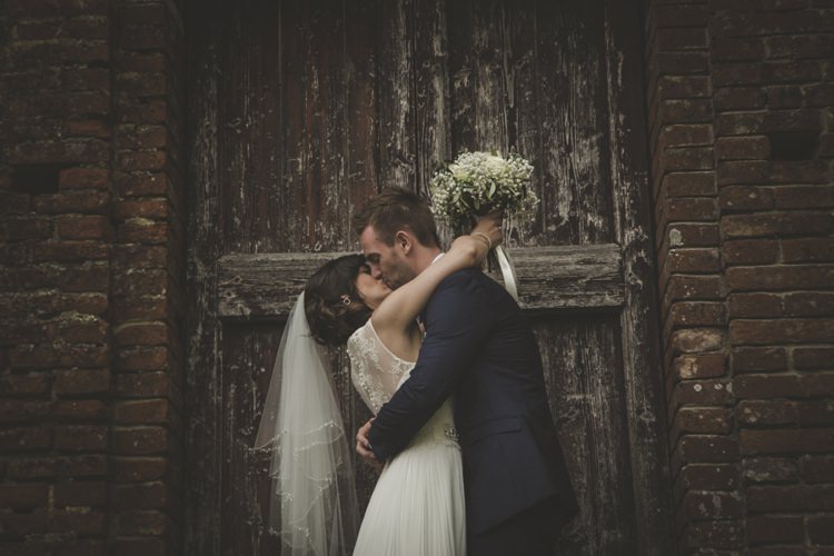 Historic Brick Building Bride Lace Sleeveless Bridal Gown Loose Curls Veil Bouquet Cream Roses Gypsophila Groom Navy Blue Suit Atmospheric Abbey Tuscany Wedding http://www.angelicabraccini.com/