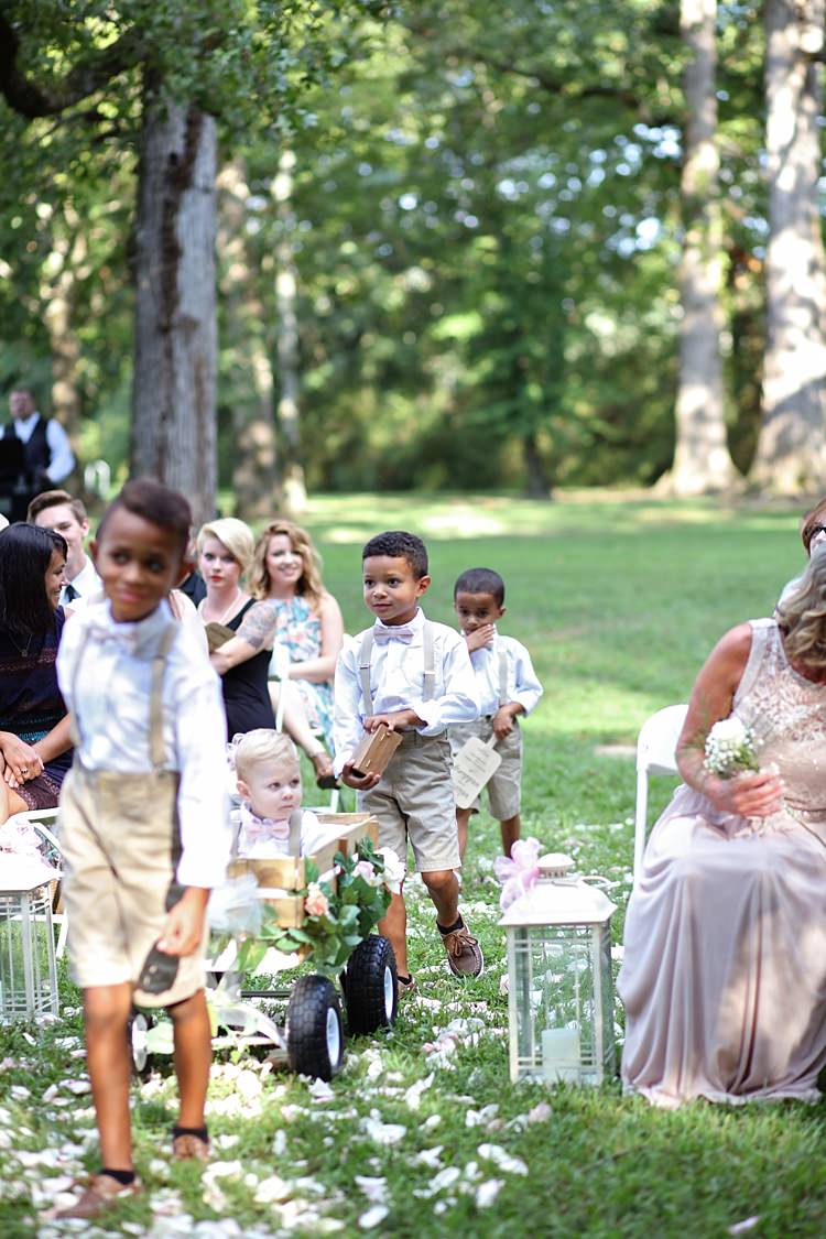 Page Boys Entrance White Shirts Beige Shorts Pale Pink Bow Ties Tan Leather Shoes Wooden Cart Candle Lanterns Trees Grass Flower Petals Guests Soft Romantic Woodland Wedding Tennessee http://www.jessicaleephotographicart.com/