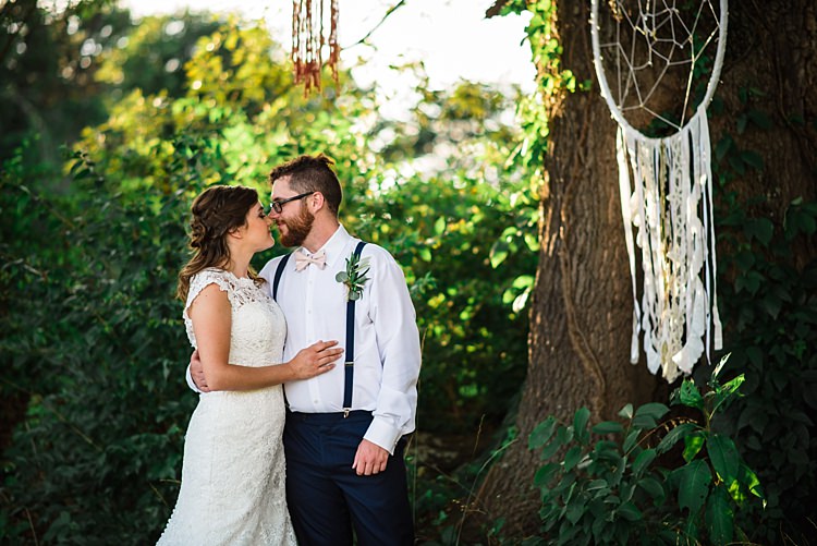 Bride Lace Bridal Gown With Buttons Groom Navy Pants Suspenders Cream Bow Tie Greenery Buttonhole Hanging Dreamcatchers Trees Ethereal Boho Wedding Ideas http://perfectcapturephoto.com/