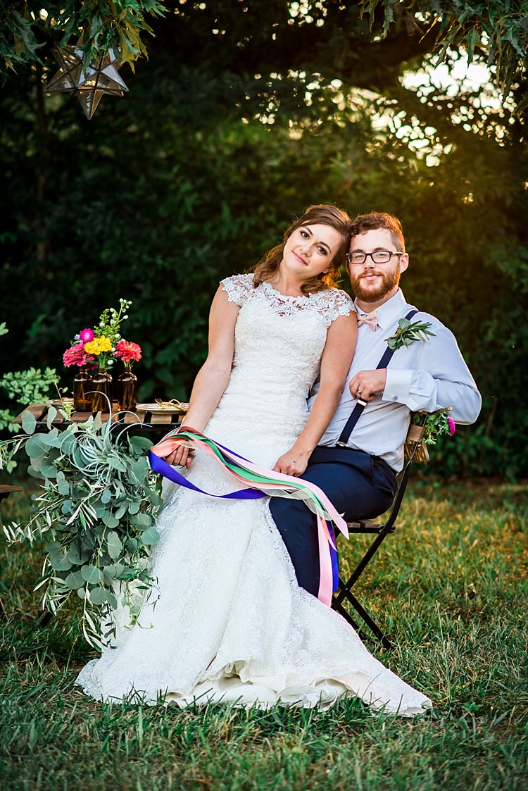Bride Lace Bridal Gown With Buttons Greenery Bouquet Multicoloured Ribbons Groom Navy Pants Suspenders Cream Bow Tie Buttonhole Table Colourful Florals Brown Glass Vases Trees Grass Ethereal Boho Wedding Ideas http://perfectcapturephoto.com/