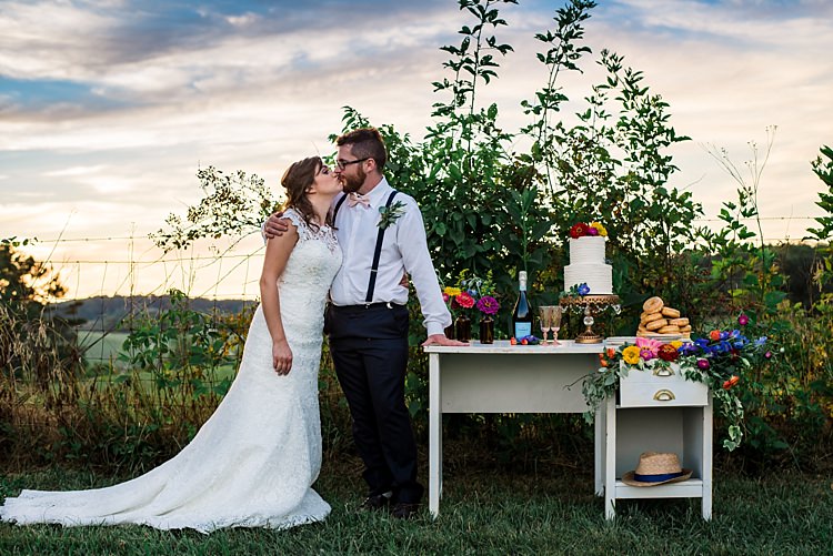 Dessert Table Wedding Cake Donuts Wine Decorated With Multicoloured Florals Brown Glass Vases Bride Lace Bridal Gown With Buttons Groom Navy Pants Suspenders Cream Bow Tie Buttonhole Ethereal Boho Wedding Ideas http://perfectcapturephoto.com/