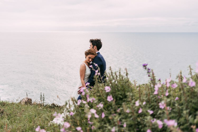 Bride Round Neck Crepe Tulle Bridal Gown Floral Hairpiece Groom Navy Blue Suit Purple Wildflowers Green Hills Ocean Romantic Bohemian Spain Wedding http://saralobla.com/