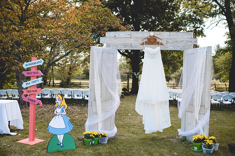 Outdoor Ceremony White Archway Curtains Strapless Bridal Gown Alice Cartoon Wooden Sign Potted Flowers Alice in Wonderland Wedding Pennsylvania http://www.julieflorophotography.com/
