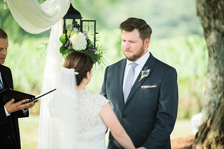 Outdoor Ceremony Bride Lace Cap Sleeve Bridal Gown Veil Groom Navy Suit Purple Tie Hanging Décor Lantern Fresh Florals Celebrant Outdoor Spring Vineyard Wedding Tennessee http://www.juicebeatsphotography.com/