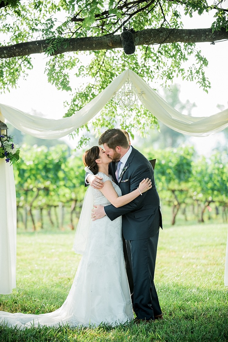 Outdoor Ceremony Bride Lace Cap Sleeve Bridal Gown Veil Groom Navy Suit Purple Tie Hanging Décor Chandelier White Fabric Kiss Outdoor Spring Vineyard Wedding Tennessee http://www.juicebeatsphotography.com/