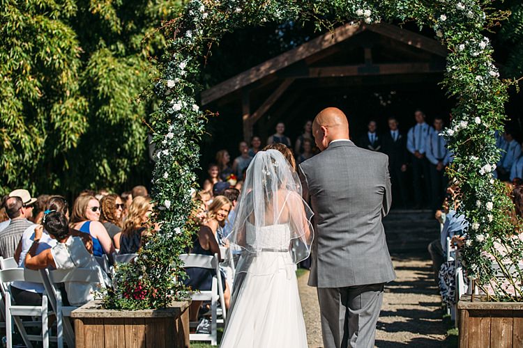 Outdoor Ceremony Entrance Bride Lace Tulle Bridal Gown Grey Sash Veil Father Guests Floral Arch Organic Farm Wedding Washington http://www.katiedayphotos.com/