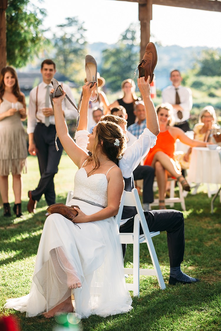 Outdoor Reception Shoe Game Bride Lace Tulle Bridal Gown Grey Sash Loose Curls Hairstyle Flowers Groom Guests Organic Farm Wedding Washington http://www.katiedayphotos.com/