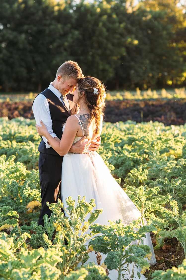 Bride Lace Tulle Bridal Gown Grey Sash Loose Curls Hairstyle Flowers Tattoo Groom Navy Blue Suit Vest Grey Tie Floral Button Hole Vegetable Patch Sunset Organic Farm Wedding Washington http://www.katiedayphotos.com/