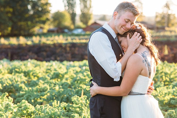 Bride Lace Tulle Bridal Gown Grey Sash Loose Curls Hairstyle Flowers Tattoo Groom Navy Blue Suit Vest Grey Tie Vegetable Patch Sunset Organic Farm Wedding Washington http://www.katiedayphotos.com/