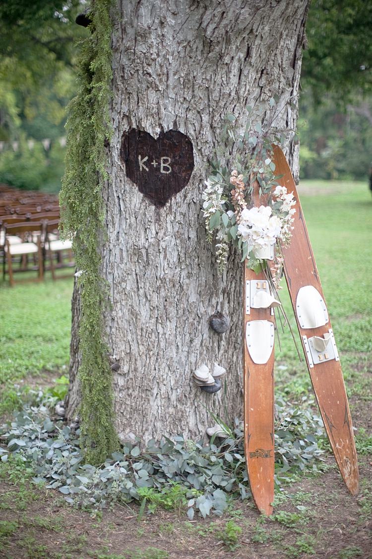 Outdoor Ceremony Tree Carving Heart Initials Wooden Skis Fresh Peach Cream Florals Gold & Peach Riverside Garden Wedding http://kellyhornberger.com/