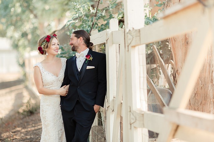 First Look Bride Lace V Neck Bridal Gown Red Maroon Rose Floral Crown Groom Black Suit White Shirt Bowtie Rose Buttonhole Luxe Outdoor Garden Wedding in California http://figlewiczphotography.com/