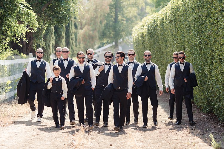 Groom Black Suit Vest White Bowtie Sunglasses Groomsmen Black Suits Black Bowties Page Boy Tall Hedge Trees Luxe Outdoor Garden Wedding in California http://figlewiczphotography.com/