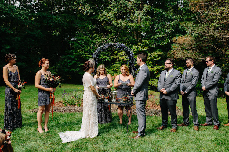 Outdoor Ceremony Floral Archway Bride Strapless Lace Watters Bridal Gown Sheer Top Birdcage Veil Groom Grey Suit Green Bowtie Sisters Officiants Bridesmaids Groomsmen Art Nouveau Autumn Burgundy Wedding http://www.jbonadiophoto.com/