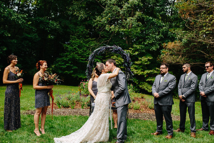 Outdoor Ceremony Floral Archway Bride Strapless Lace Watters Bridal Gown Sheer Top Birdcage Veil Groom Grey Suit Green Bowtie Kiss Bridesmaids Groomsmen Art Nouveau Autumn Burgundy Wedding http://www.jbonadiophoto.com/