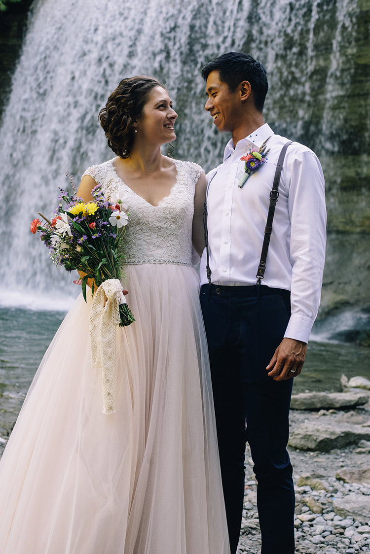 Bride Allure Champagne Lace Tulle Bridal Gown Multicoloured Floral Bouquet Lace Ribbon Groom White Shirt Brown Leather Suspenders Navy Pants Multicoloured Floral Buttonhole Woodland Waterfall Mint Wedding Ontario http://www.laurenmccormickphotography.com/