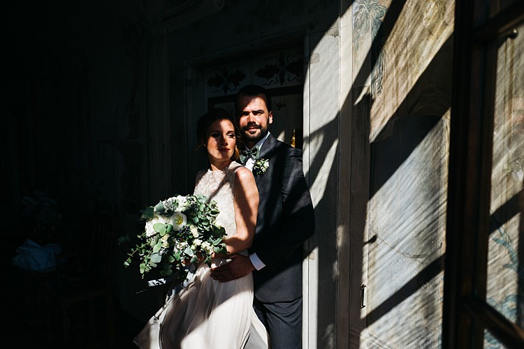 Bride High Neck Lace Tulle Bridal Gown Bouquet White Roses Greenery Groom Charcoal Pinstripe Suit Green Patterned Bowtie Shadows Rustic Chic Greenery Wedding Ideas in Tuscany http://www.tastino0.it/