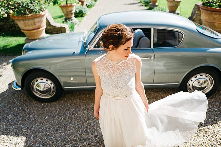 Bride High Neck Lace Tulle Bridal Gown Loose Curls Hairstyle Vintage Grey Car Large Potted Plants Rustic Chic Greenery Wedding Ideas in Tuscany http://www.tastino0.it/