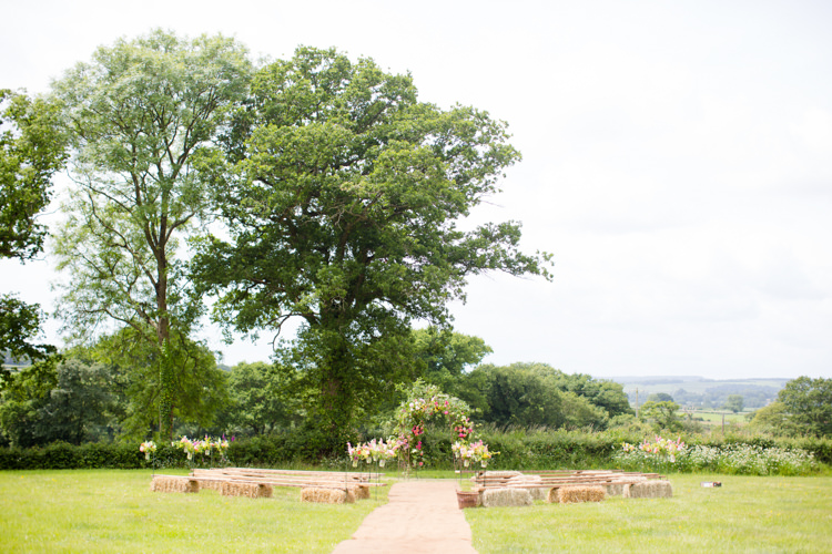 Outdoor Ceremony UK Hay Bales Arch Flowers Colourful Pastel Home Made Farm Wedding http://helencawtephotography.com/