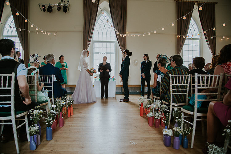 Village Hall Ceremony Festoon Lights Colourful Crafty Relaxed Watercolour Wedding https://suesliquephotography.com/