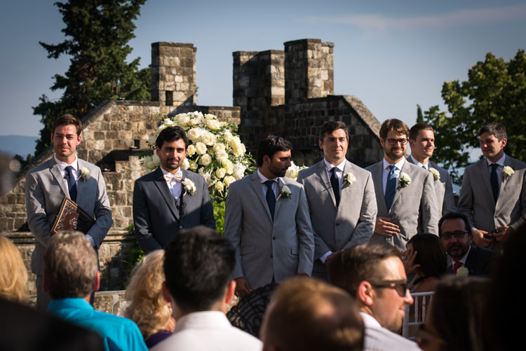 Outdoor Ceremony Groom Black Suit White Bowtie Floral Buttonhole Groomsmen Celebrant Guests White Roses Romantic Outdoor Castle Tuscany Wedding http://www.natalymontanari.com/