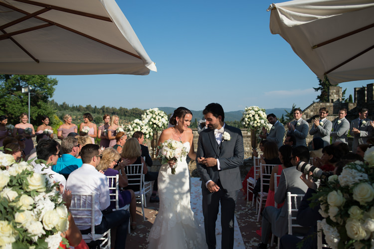 Outdoor Ceremony Bride Fitted Lace Mermaid Bridal Gown Groom Black Suit White Shirt White Bowtie Guests White Chairs White Roses Umbrellas Romantic Outdoor Castle Tuscany Wedding http://www.natalymontanari.com/