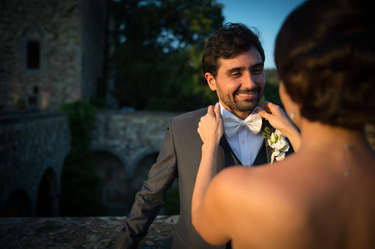 Sunset Groom Black Suit White Shirt White Bowtie White Floral Buttonhole Bride Romantic Outdoor Castle Tuscany Wedding http://www.natalymontanari.com/