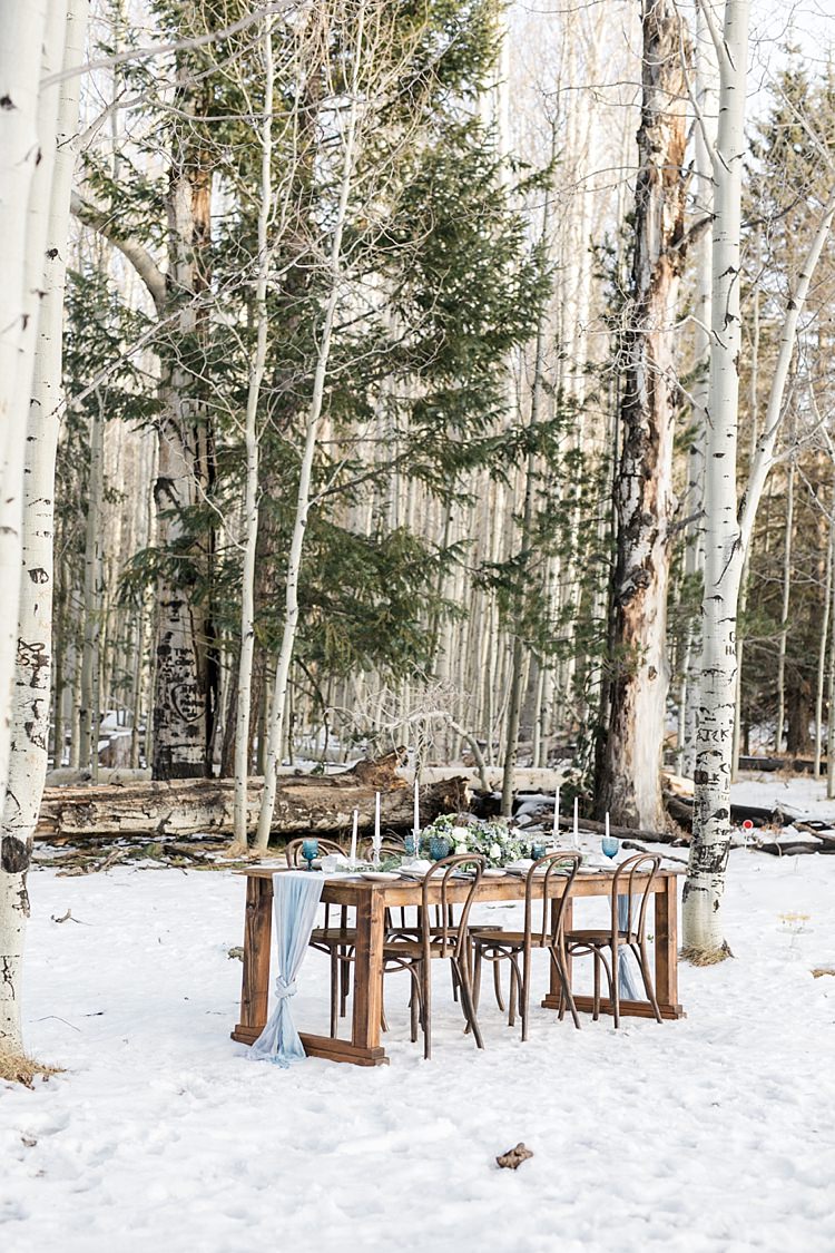 Outdoor Reception Wooden Table Blue Fabric Candlesticks Fresh Florals Tall Trees Snowy Winter Wonderland Anniversary Shoot http://ryannlindseyphotography.com/