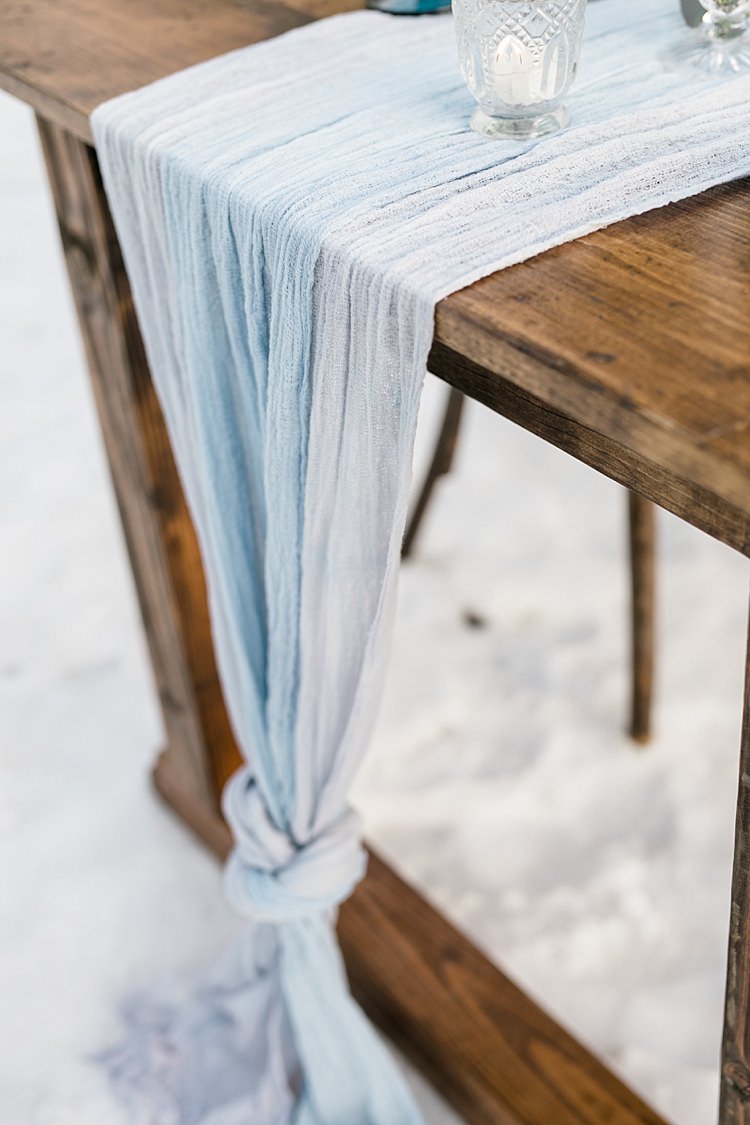 Outdoor Reception Wooden Table Blue Grey Fabric Candles Glass Holders Snowy Winter Wonderland Anniversary Shoot http://ryannlindseyphotography.com/