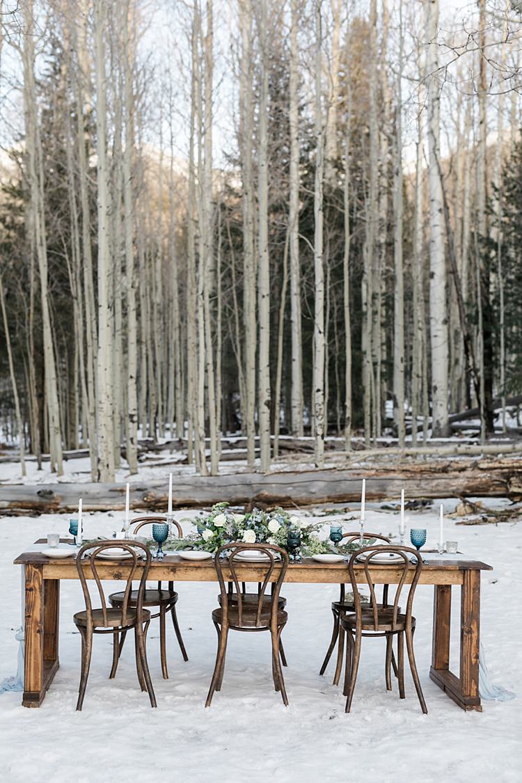 Outdoor Reception Wooden Table Blue Grey Fabric Fresh White Blue Green Flowers Candlesticks Blue Wine Goblets Snowy Winter Wonderland Anniversary Shoot http://ryannlindseyphotography.com/
