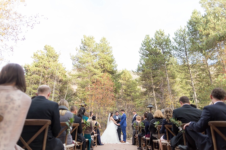 Outdoor Ceremony Bride Groom Celebrant Guests Autumn Trees Wooden Chairs Romantic Mountain Wedding Colorado http://irvingphotographydenver.com/