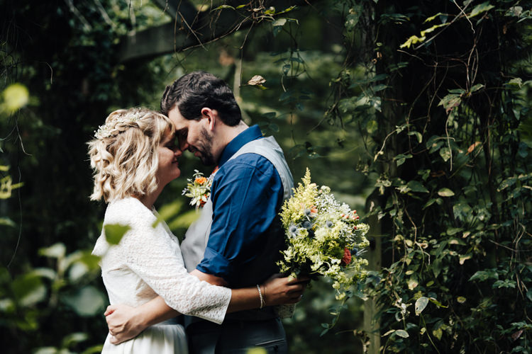 Outdoor First Look Bride Handmade Lace Floral Belt Bridal Gown Bouquet Orange Carnations Thistle Gypsophila Groom Grey Vest Pants Navy Blue Shirt Buttonhole Orange Florals Succulent Adventure Inspired Woodland Wedding North Carolina http://www.amandasuttonphotography.com/